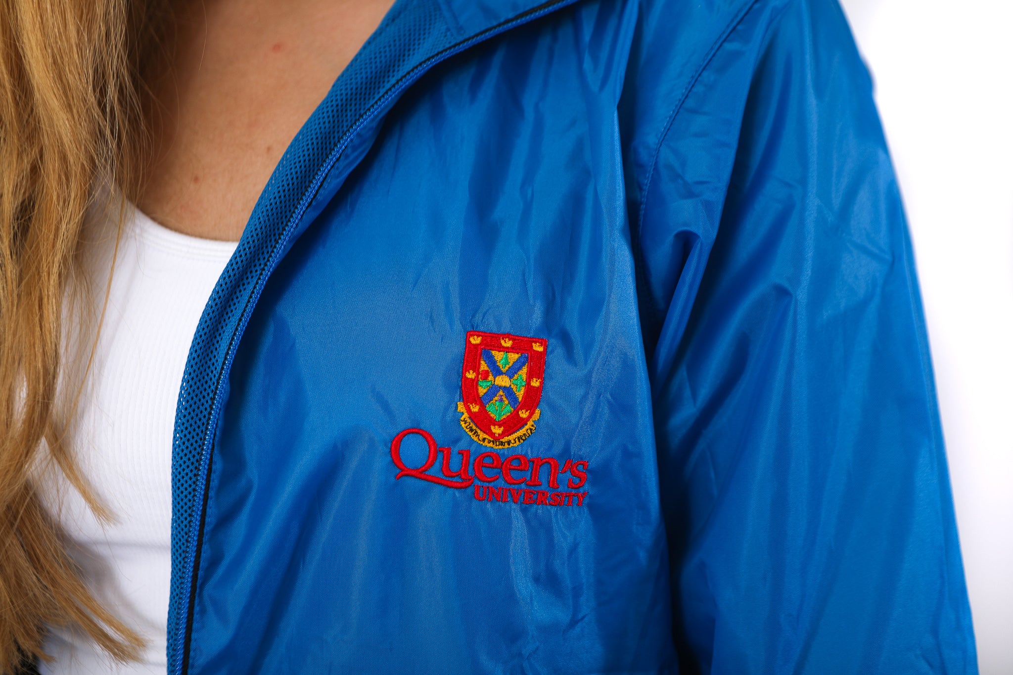 Close up of blue zip up rain jacket with red Queen's crest logo