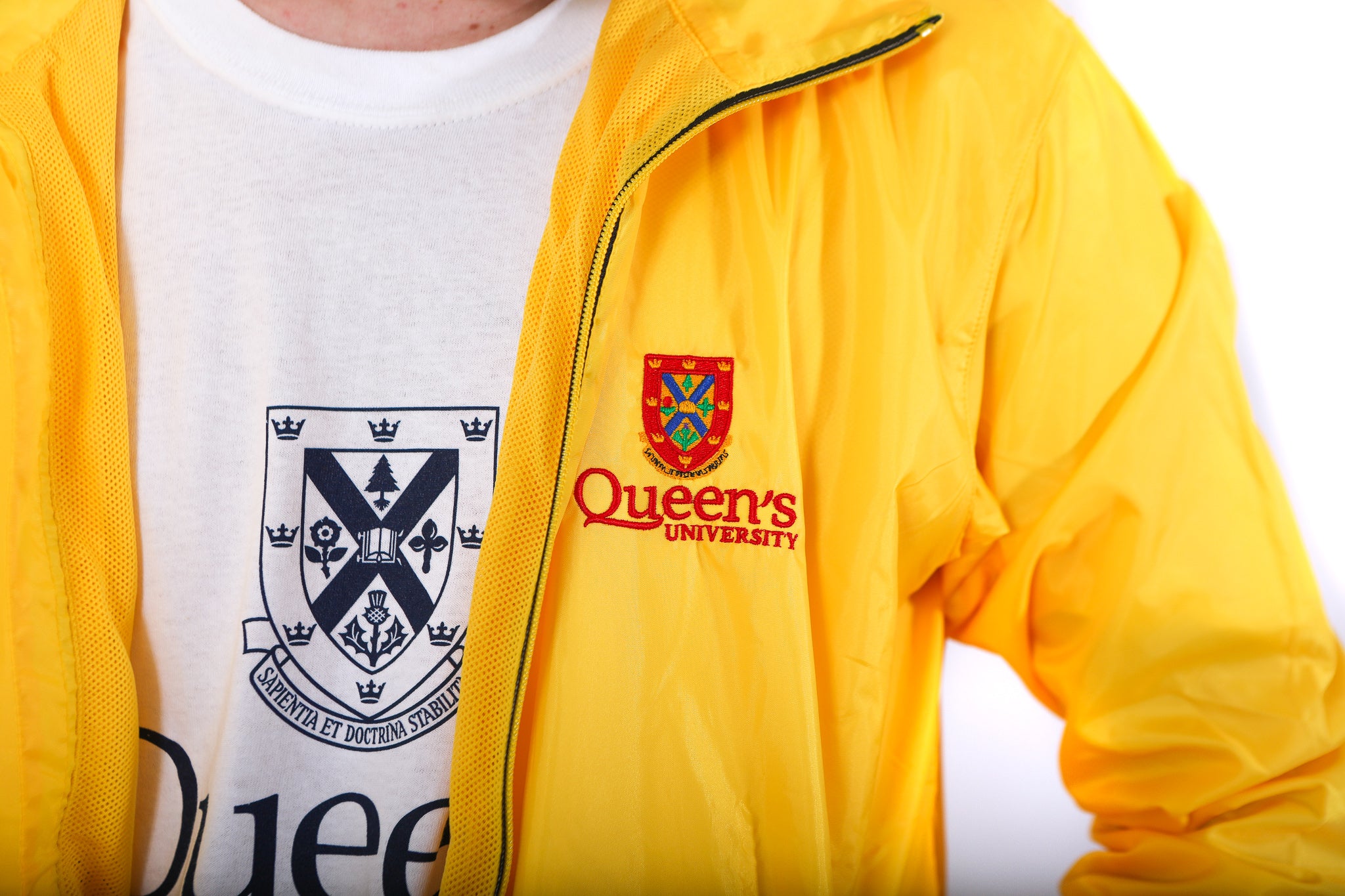 Close up of yellow zip up rain jacket with red Queen's crest logo