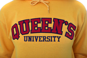 Close up of red Queen's logo on yellow sweater